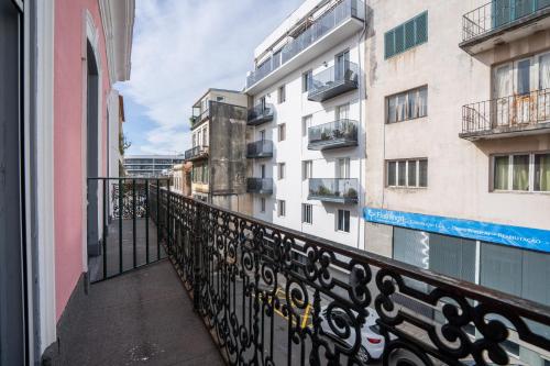 a balcony with a black fence and buildings at Madeirarooms in Funchal