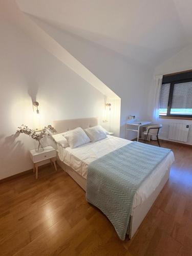 a bedroom with a large bed and a desk at O Ático in Rosal