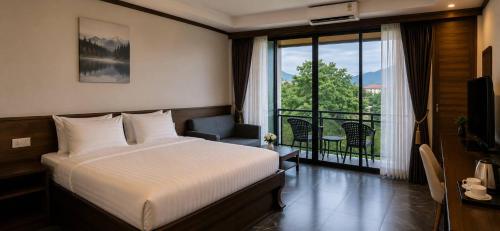 a hotel room with a bed and a balcony at Chomphu Phukha Resort-Mountain View Nan in Pua