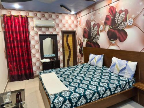 a bedroom with a bed and a wall with flowers at Hotel Serena in Hyderabad