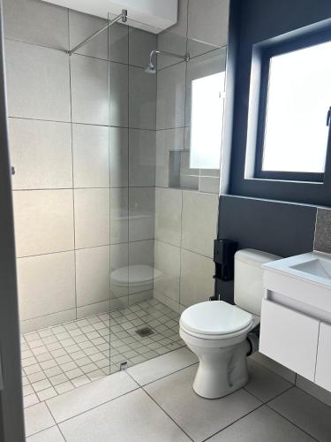 a bathroom with a toilet and a glass shower at 161 green valley in Boschrand