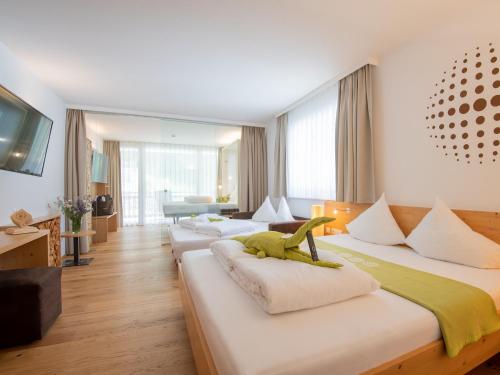 a hotel room with three beds with a dinosaur on them at Natürlich Hotel mit Charakter in Fiss