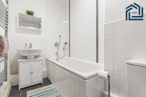 a white bathroom with a sink and a toilet at Reading City Getaway Stylish Flat, Sleeps 2 in Reading
