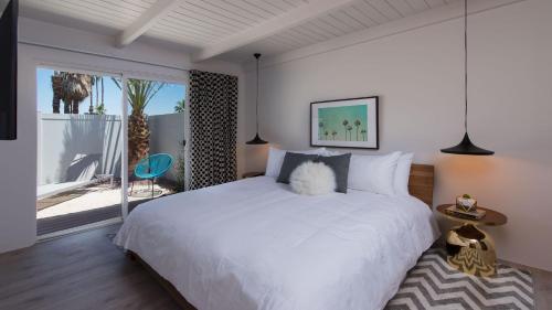 a bedroom with a white bed and a large window at The Weekend by AvantSay in Palm Springs