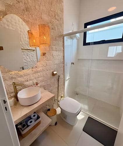 a bathroom with a white toilet and a sink at Wp White House- Estilo Grego 7 min do aqualinda in Andradina