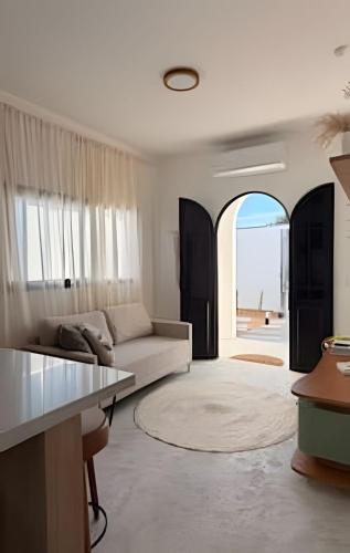 a living room with a couch and an open window at Wp White House- Estilo Grego 7 min do aqualinda in Andradina