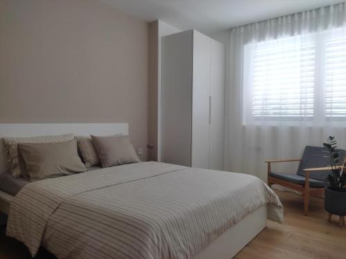a white bedroom with a bed and a window at Gardena Living in Ponte Gardena