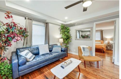 a living room with a blue couch and a table at Downtown WS bungalow Close to Everything in Winston-Salem