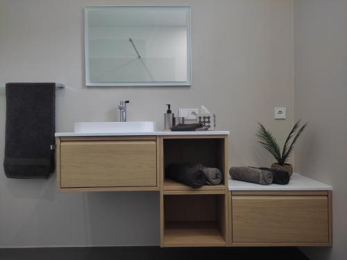 a bathroom with a sink and a cabinet with towels at Gardena Living in Ponte Gardena