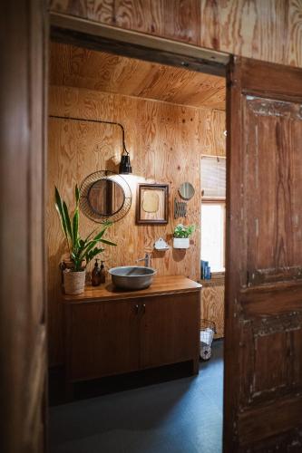 a bathroom with a sink and a wooden wall at Wdech Wydech in Chełsty