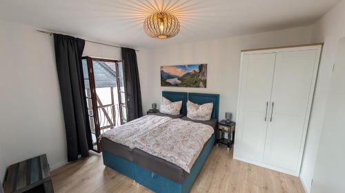 a bedroom with a blue bed and a chandelier at Ferienwohnung Lehmann in Wolfenbüttel