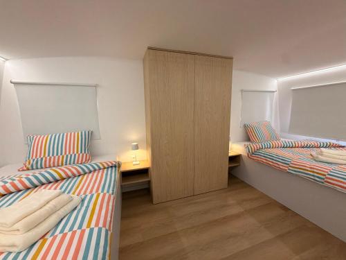 a small room with two beds and a cabinet at Panonska hiška - Panonian nest - vključeni 2 kopalni karti za Terme3000 in Moravske-Toplice