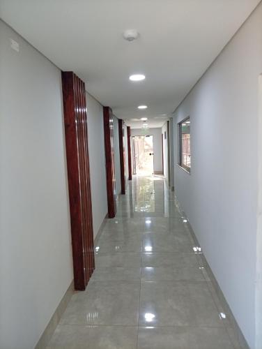 an empty hallway with white walls and a tile floor at Terraza Frontera Hotel in Pedro Juan Caballero