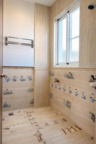 a bathroom with a shower with blue birds on the floor at 跳跳民宿 包棟首選 離島慢活 海島體驗 浮潛潛水 生態旅遊 in Xiaoliuqiu