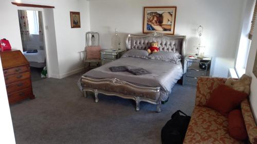 a bedroom with a large bed and a couch at The Post Office, 6 beds, Bar, Library, Pool Table, Stream, Large Garden in Piddletrenthide