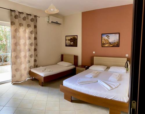 a hotel room with two beds and a window at Dhimitri Rooms in Gjilek