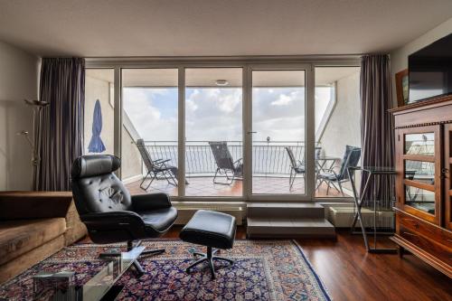 a living room with a view of a balcony at Exklusive Ferienwohnung am Südstrand mit Panoramabalkon & Meerblick Wohnung 92 in Wilhelmshaven