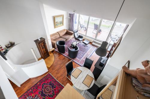 an overhead view of a living room with a table and chairs at Exklusive Ferienwohnung am Südstrand mit Panoramabalkon & Meerblick Wohnung 92 in Wilhelmshaven