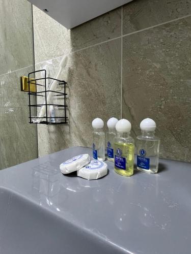a counter with four bottles of detergents on it at Стильная студия в центре с кухней in Bukhara