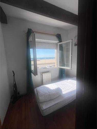 a bedroom with a bed and a large window at Maison 5 chambres front de mer classée 3 étoiles tourisme in Narbonne