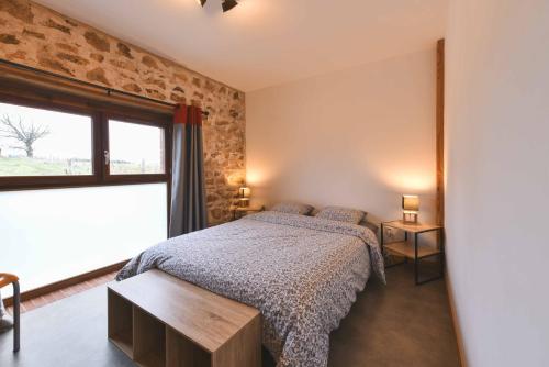 a bedroom with a bed and a large window at Gîte à La Ferme de l'Oasis in Saint-Marcel-de-Félines