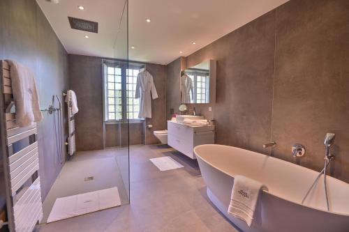 a large bathroom with a tub and a shower at Château de Taradel in Taradeau
