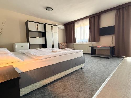 a large bedroom with two beds in it at Patyi Étterem és Hotel in Bögöte