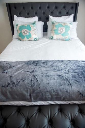 a large bed with a black headboard and pillows at Home Very Close To CBD in Gaborone