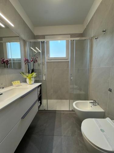 a bathroom with a sink and a toilet and a shower at Hotel Eden in Lignano Sabbiadoro