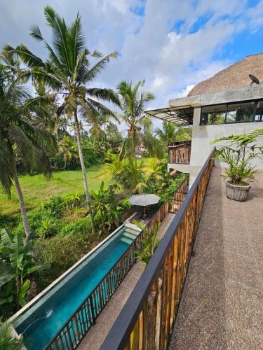 a house with a swimming pool next to a resort at Bali View Ubud Hotel in Ubud