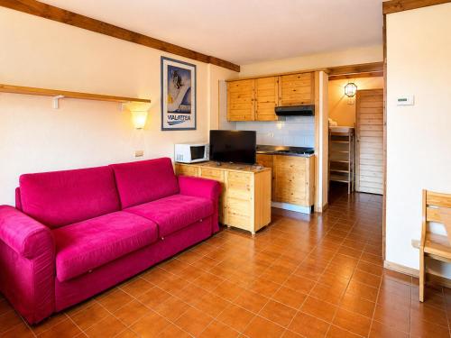 a living room with a red couch and a kitchen at Hostdomus - A3-07 in Grange Sises