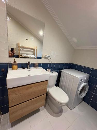 a bathroom with a toilet and a sink and a mirror at O Ático in Rosal