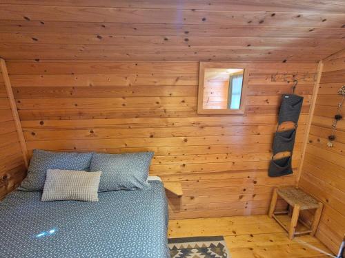 a bedroom with a bed in a wooden wall at Camp The sunrise hill in Pivka