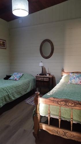 a bedroom with two beds and a table and a mirror at La Soñada in San Javier