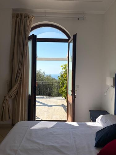 a bedroom with a bed and an open door at Complesso San Francesco in Massa Lubrense