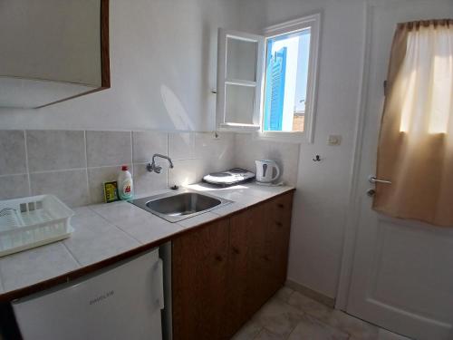 a small kitchen with a sink and a window at Fragos Apartments in Santa Maria