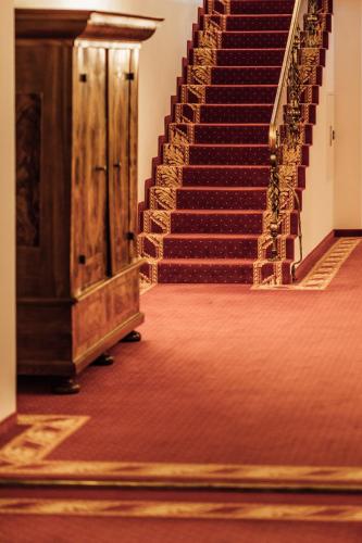 an empty staircase in a building with red carpet at Hotel Zürserhof in Zürs am Arlberg
