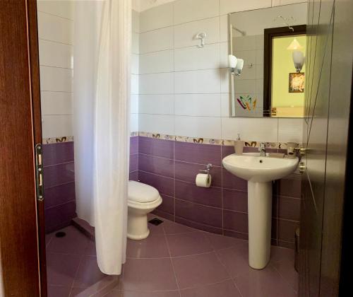 a bathroom with a toilet and a sink at Dhimitri Rooms in Gjilek