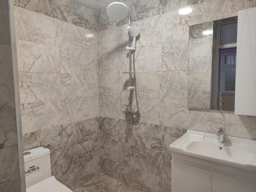 a bathroom with a sink and a toilet and a mirror at Bright Modern Suite in Quba
