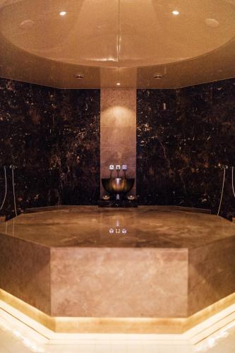 a bathroom with a bath tub with a sink at Hotel Zürserhof in Zürs am Arlberg