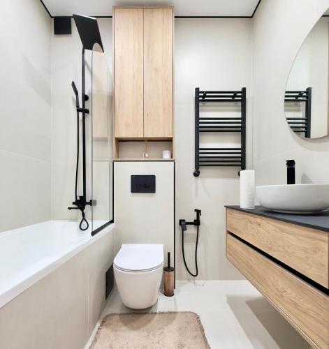 a bathroom with a white toilet and a sink at Rent&live beautiful apartment in Chişinău