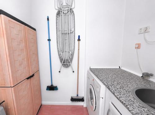 a laundry room with a washing machine and mop at Villa Banfield in Gran Alacant