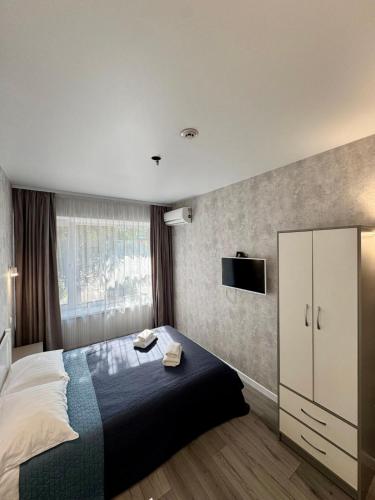 a bedroom with a bed and a tv on the wall at Готель Elisavetgrad in Kropyvnytskyi