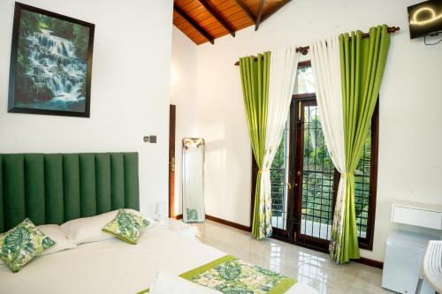 a bedroom with a bed and a large window at Regal Retreat in Mahawatta