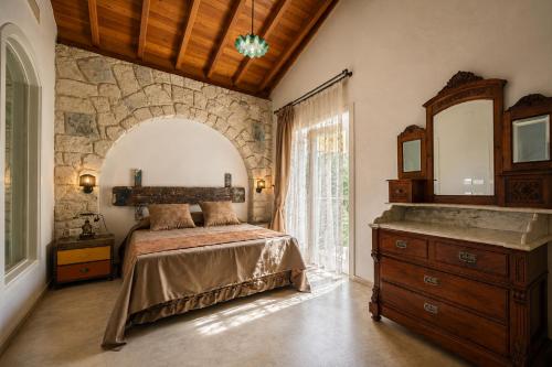 a bedroom with a bed and a dresser and a mirror at Alacati Kostem Hotel - Special Category in Alaçatı
