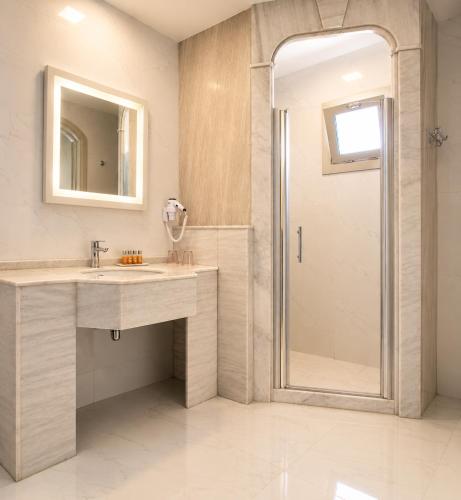 a bathroom with a sink and a shower with a mirror at Alacati Kostem Hotel - Special Category in Alaçatı