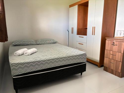 a bedroom with a bed with two pillows on it at Kitnet Vista do Vale in Areia