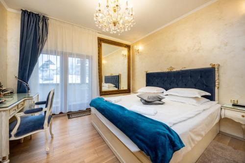 a bedroom with a large bed and a mirror at Pensiunea Cameea Busteni in Buşteni