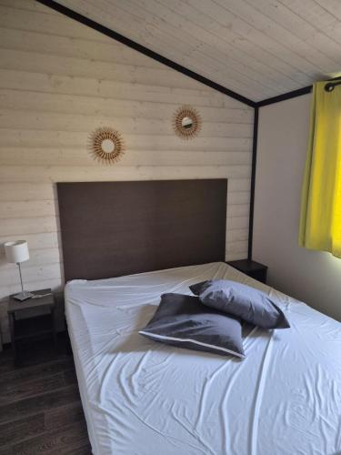 a bed with two pillows on it in a bedroom at Chalet a louer avec piscine in Solliès-Toucas