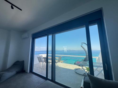 a room with a sliding glass door with a view of the ocean at NV seafront Villa with private pool & NV seafront luxury suites no pool acces - Aegina in Áyioi